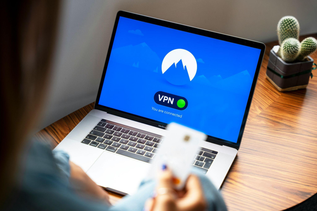 A person using a laptop with a VPN application enabled to secure internet access.