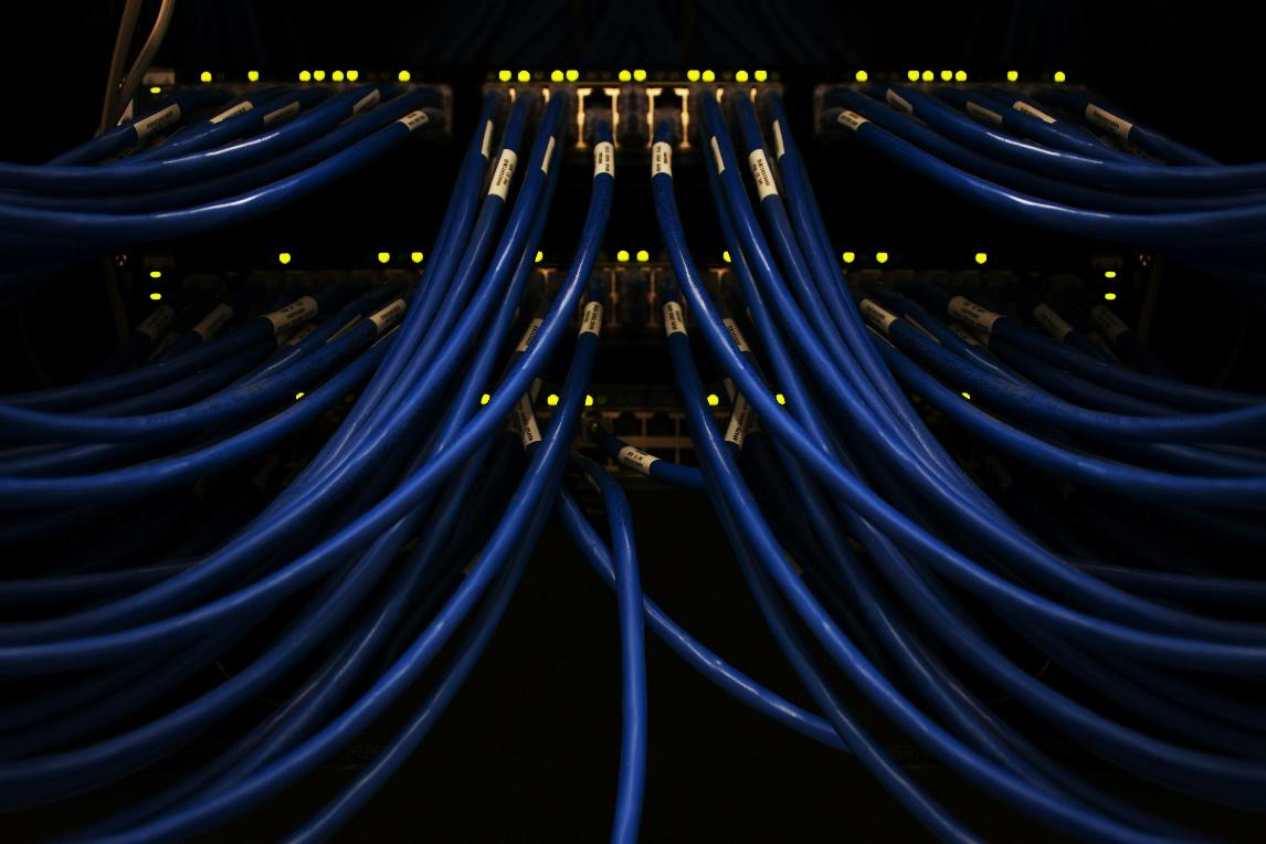 Blue network cables connected in a data center supporting cloud infrastructure.